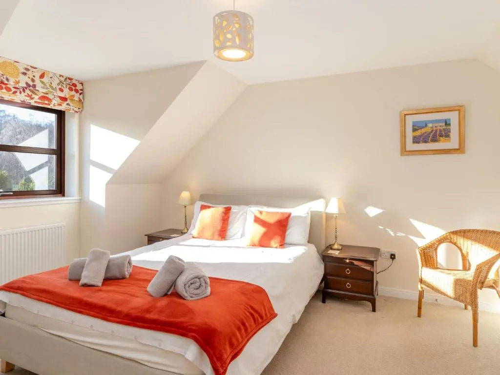 a bedroom with a bed with a red blanket at Villa Pineways by Interhome in Aviemore