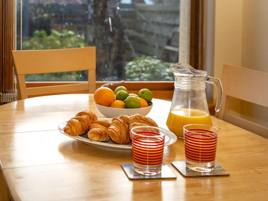 a table with a plate of food and a bowl of fruit at Holiday Home Skye Premier by Interhome in Aviemore