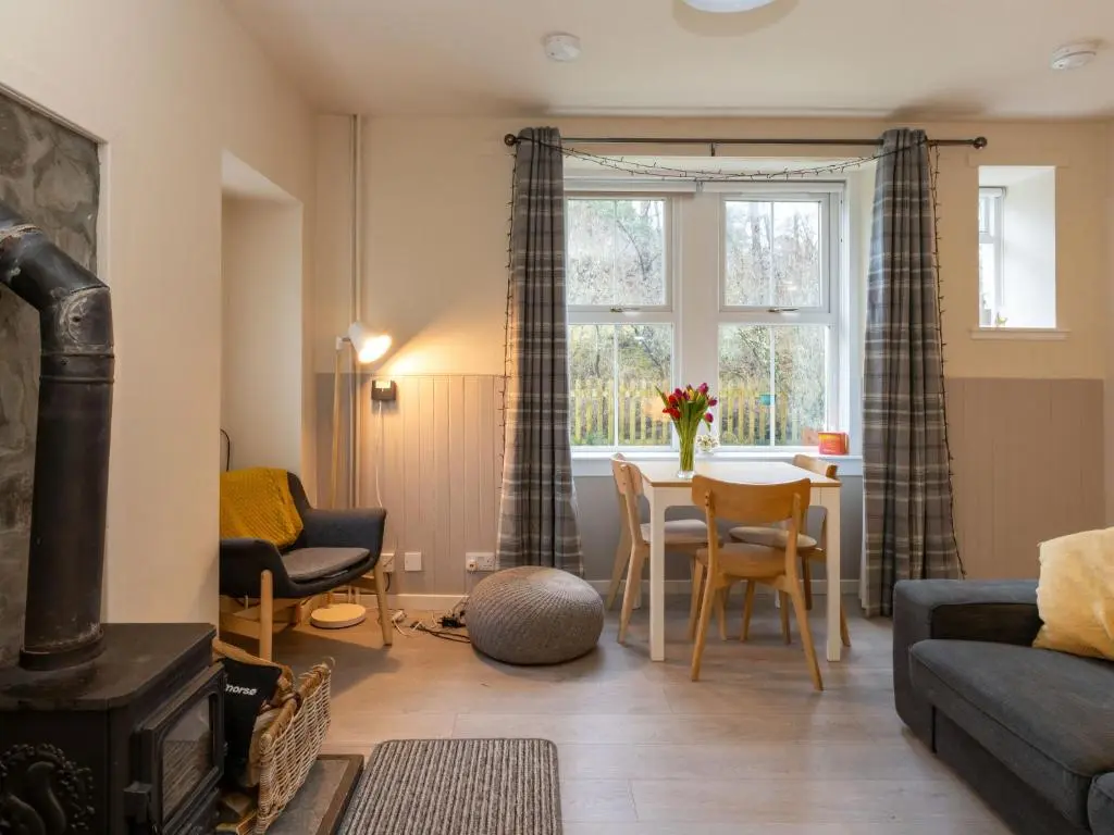 a living room with a couch and a table at Holiday Home 2 Railway Cottage by Interhome in Aviemore