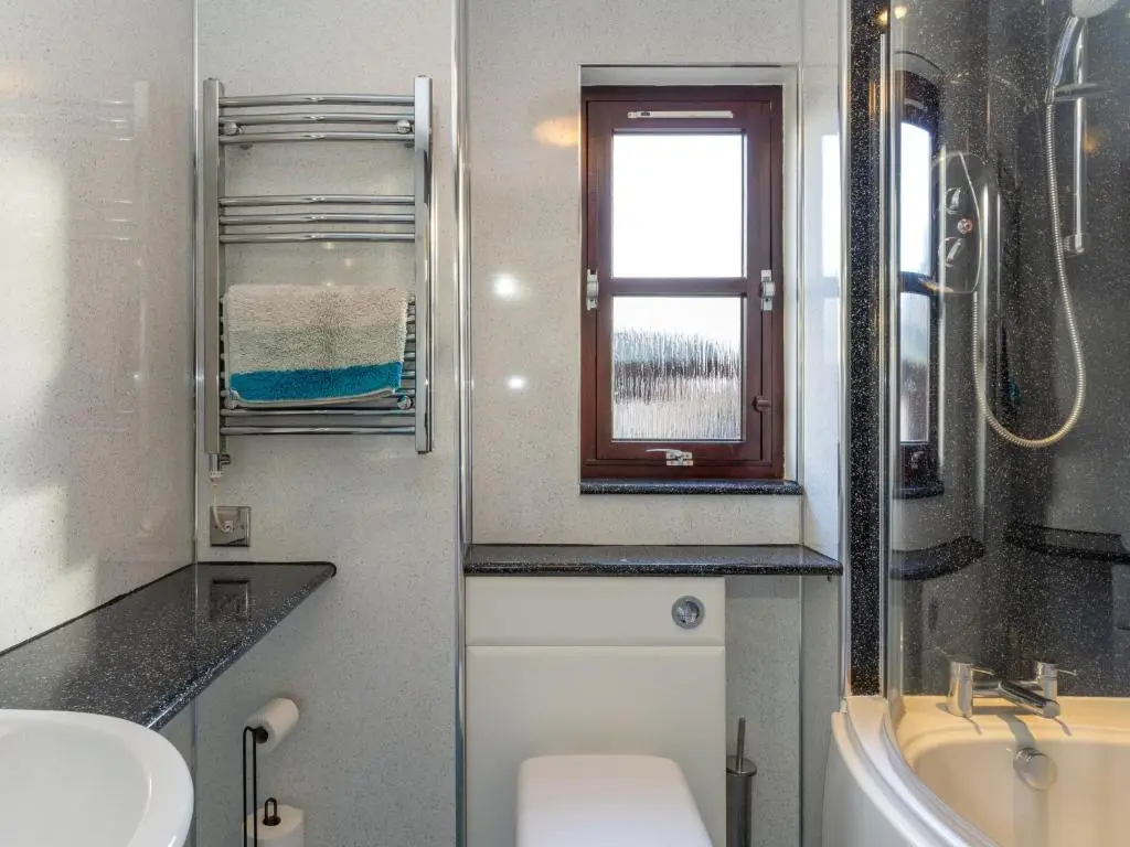 a bathroom with a sink and a toilet and a window at Holiday Home Glenfiddich by Interhome in Aviemore