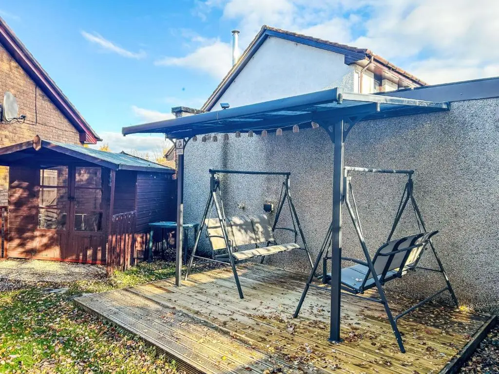 a swing set in front of a building at Holiday Home Glenfiddich by Interhome in Aviemore