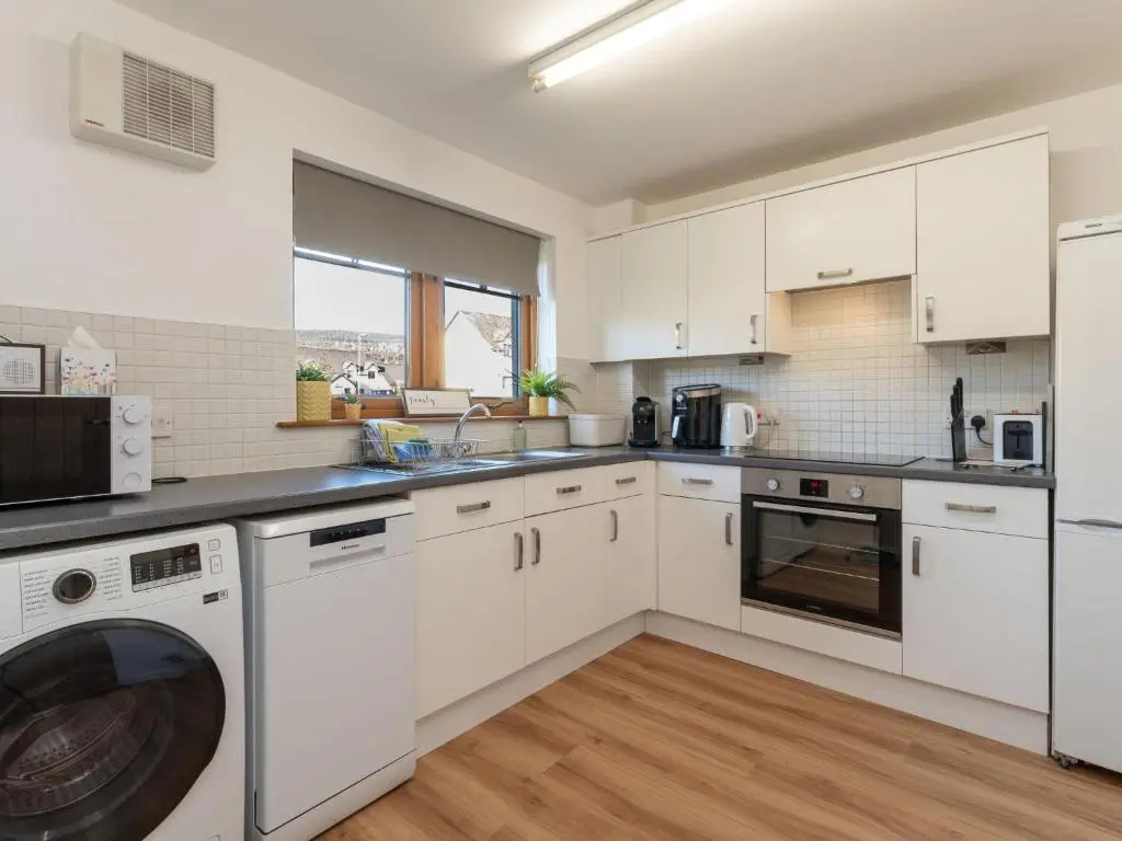 a kitchen with white cabinets and a dishwasher at Apartment The Bruach by Interhome in Aviemore