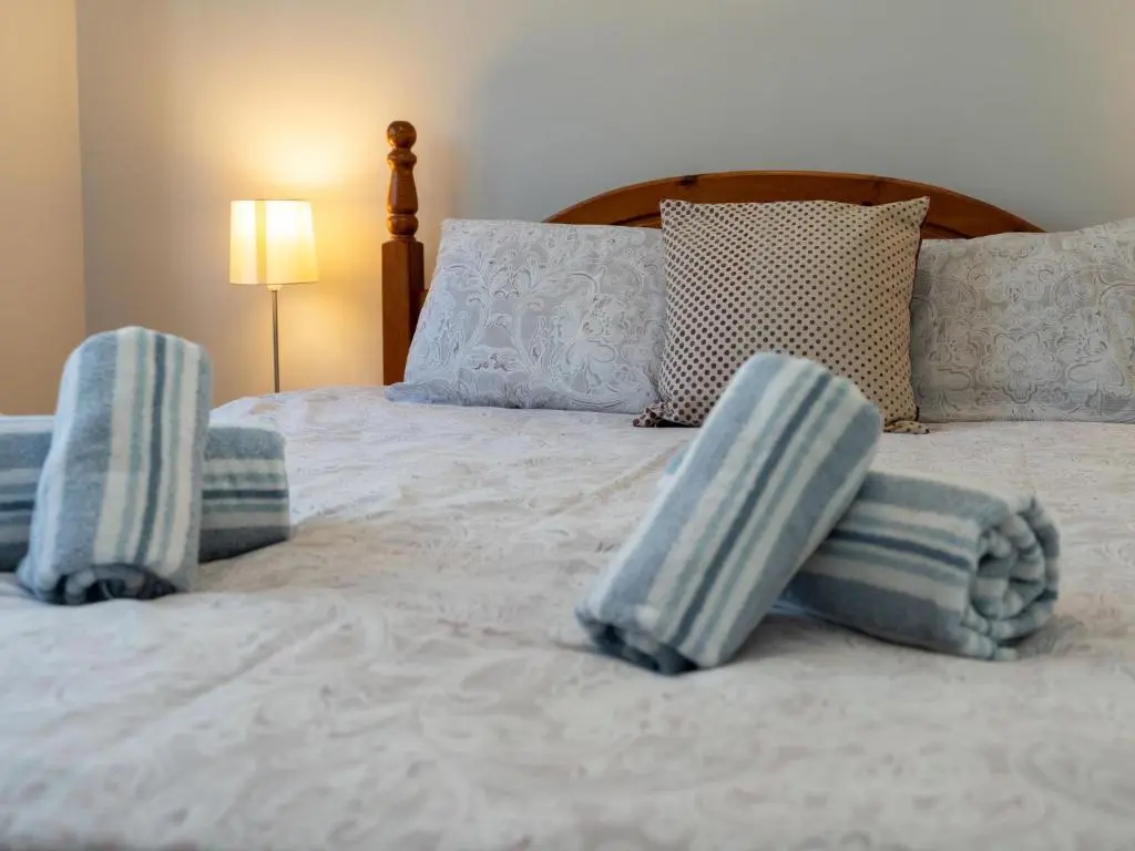 a bed with blue and white pillows on it at Holiday Home Cosagach Cottage by Interhome in Aviemore
