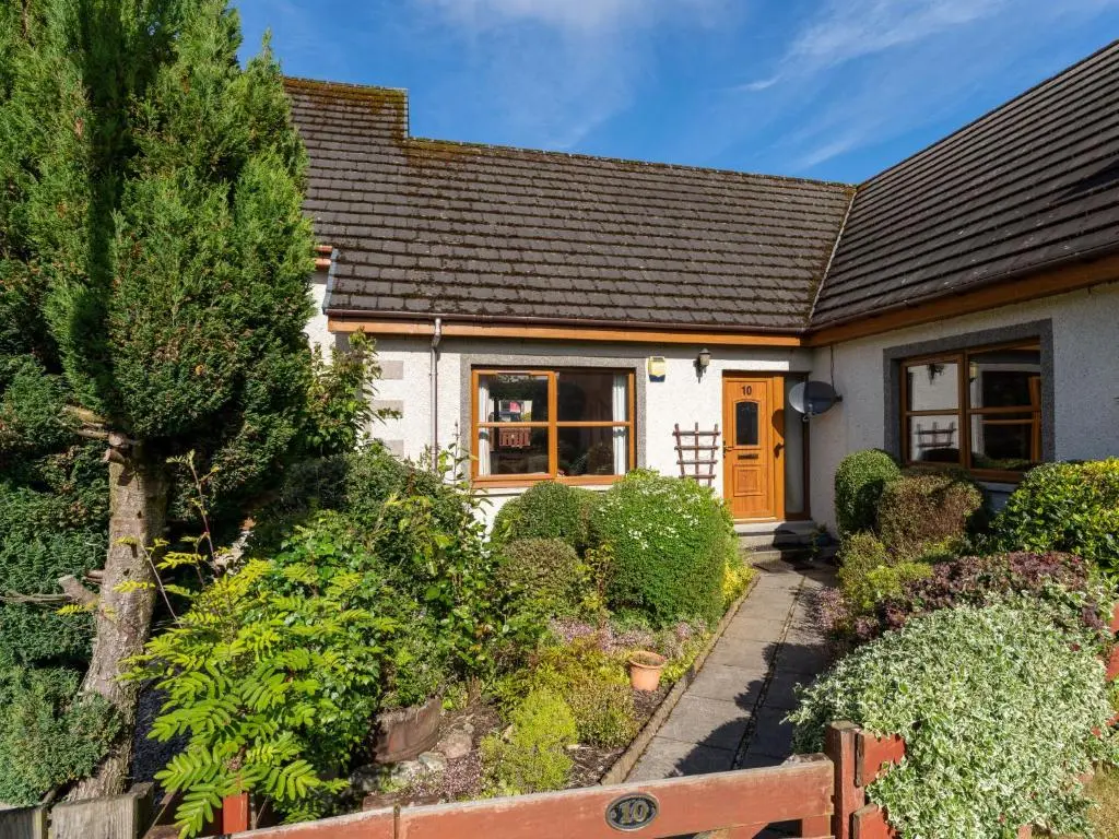 a small white house with a brown roof at Holiday Home Braeriach by Interhome in Aviemore