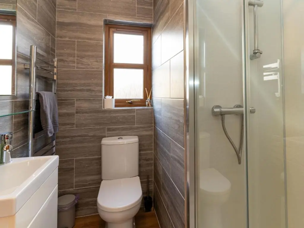 a bathroom with a toilet and a glass shower at Holiday Home Braeriach by Interhome in Aviemore