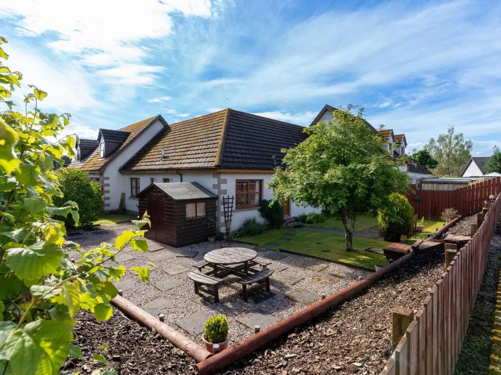 a house with a picnic table in the yard at Holiday Home Braeriach by Interhome in Aviemore