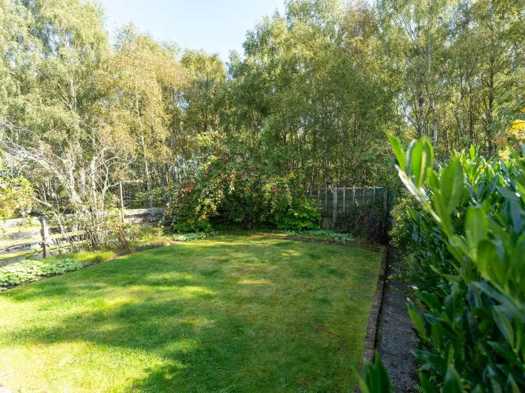 a backyard with a fence and a grass yard at Holiday Home Glenpark by Interhome in Aviemore