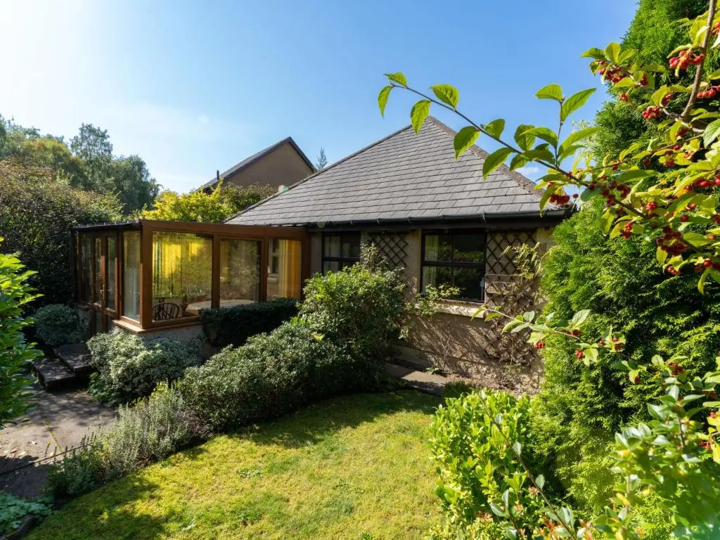 a house with a garden and a glass house at Holiday Home Glenpark by Interhome in Aviemore