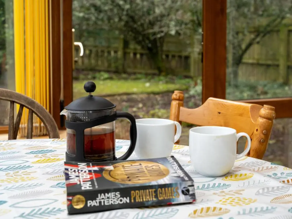 a tea kettle sitting on a table with two cups at Holiday Home Glenpark by Interhome in Aviemore