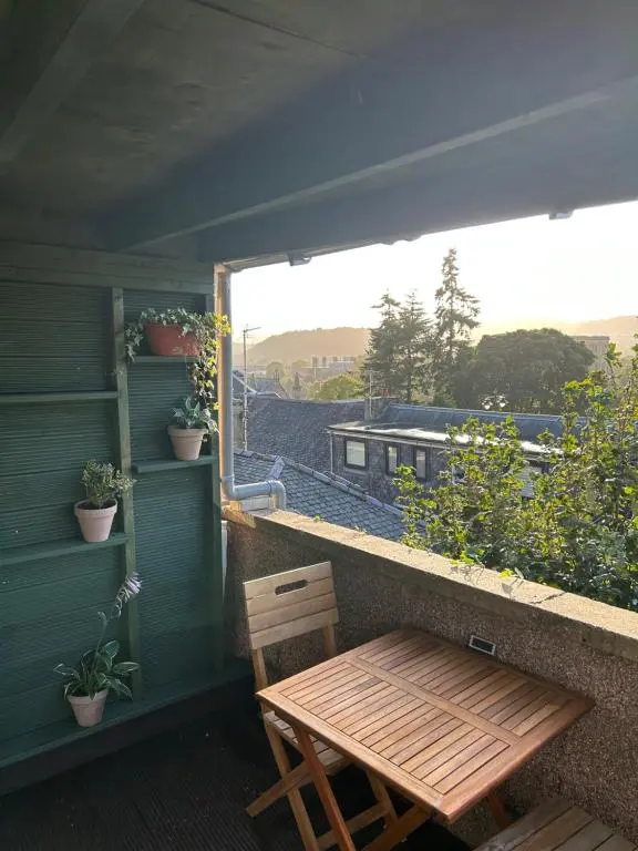 a wooden table and chairs on a balcony with a view at Floras View in Inverness