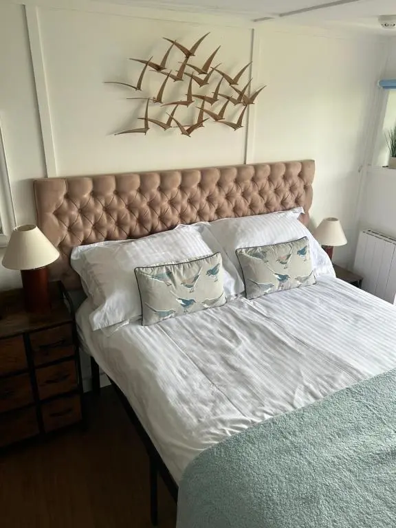 a bedroom with a large bed with a large headboard at Floras View in Inverness