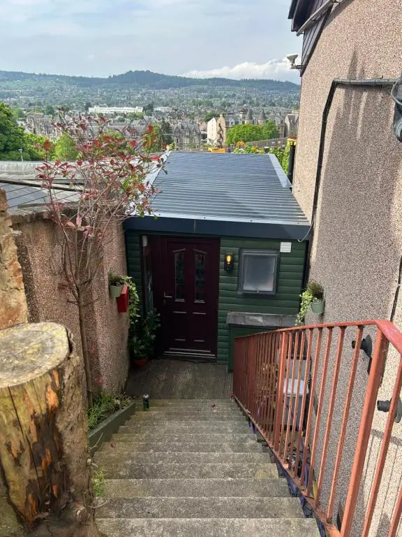 a small green building with a door and stairs at Floras View in Inverness