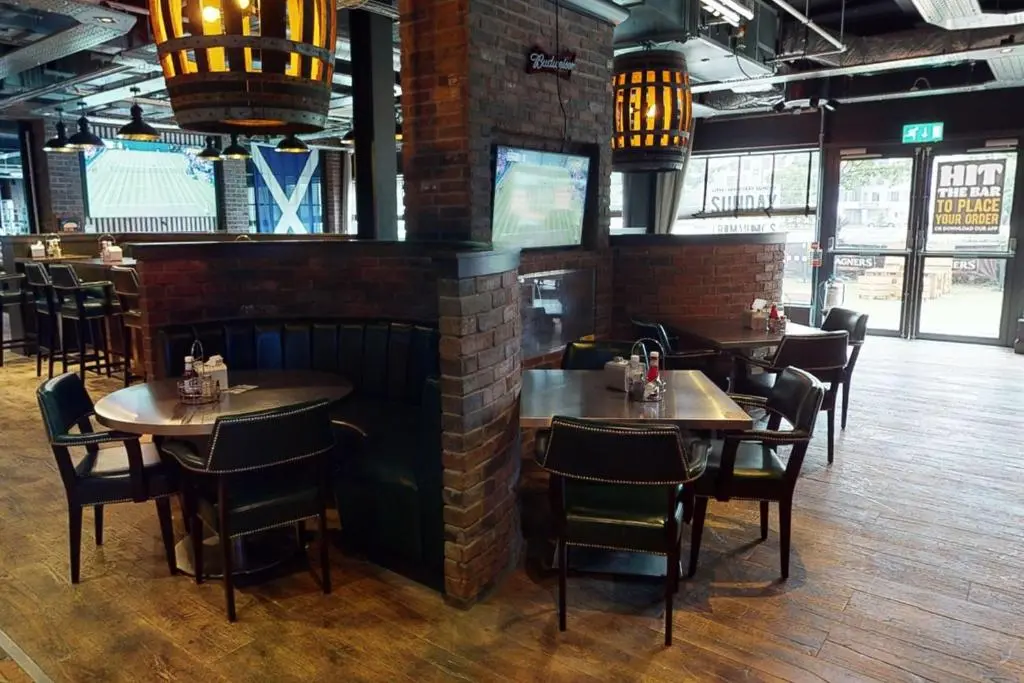 a restaurant with tables and chairs in a room at Village Hotel Aberdeen in Aberdeen