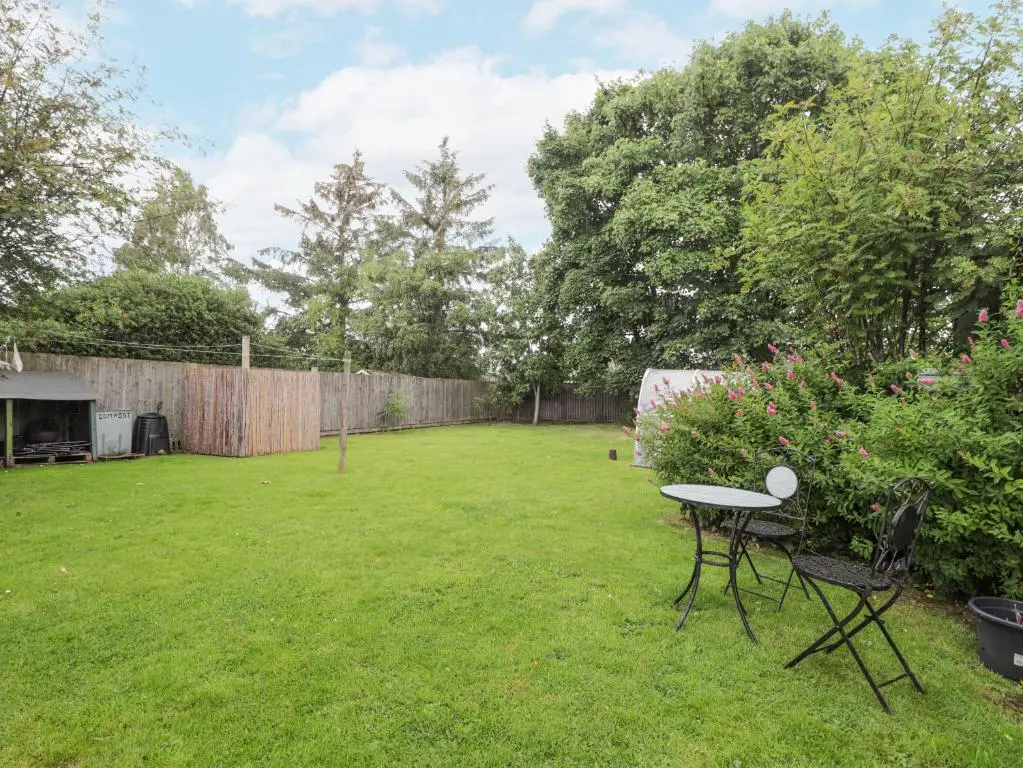 a yard with a table and a fence at Rowan Tree House in Brora