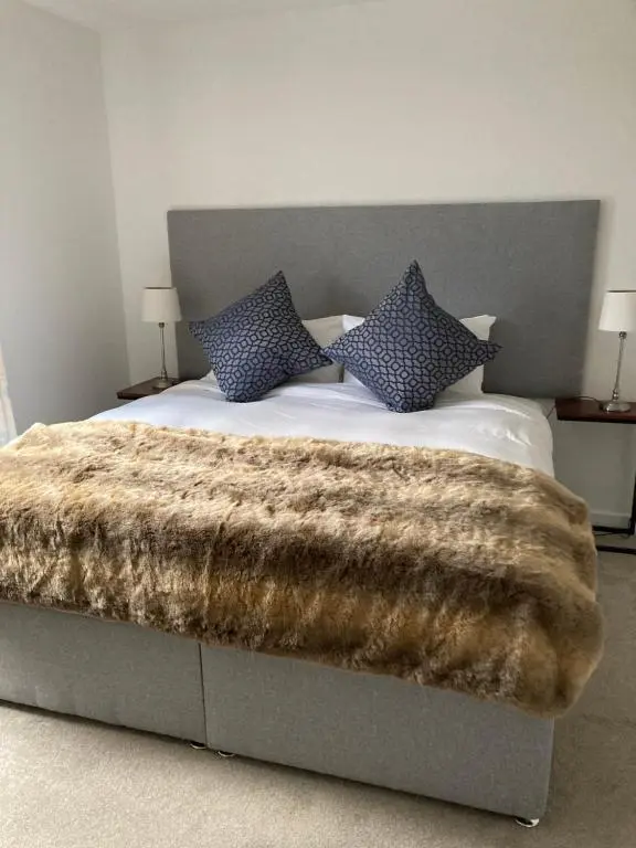 a bed with a furry blanket on top of it at Highland Holiday Home in Contin