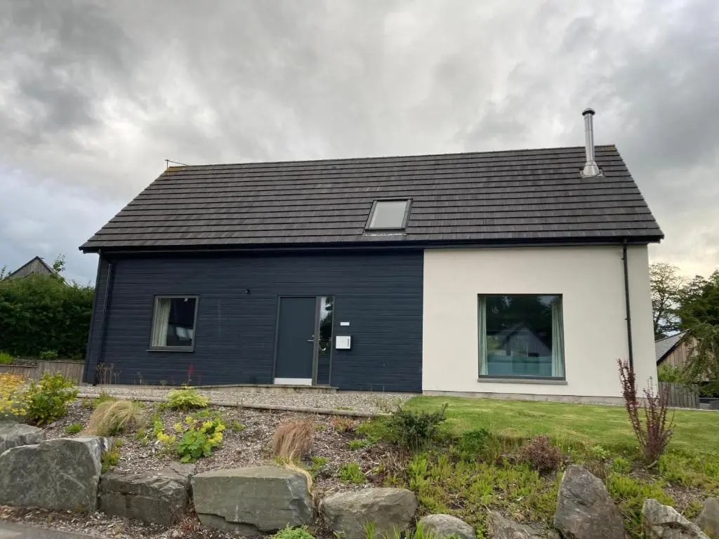 a black and white house with at Highland Holiday Home in Contin