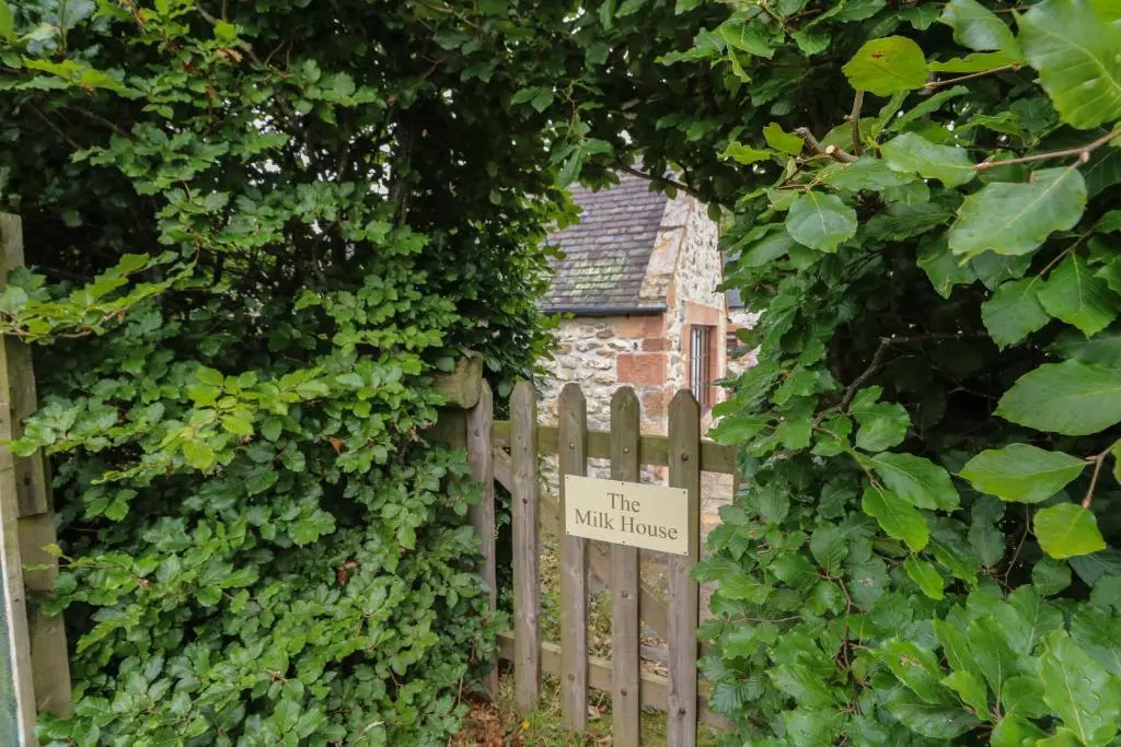 a wooden fence with a sign that reads the wild house at The Milk House in Fortrose