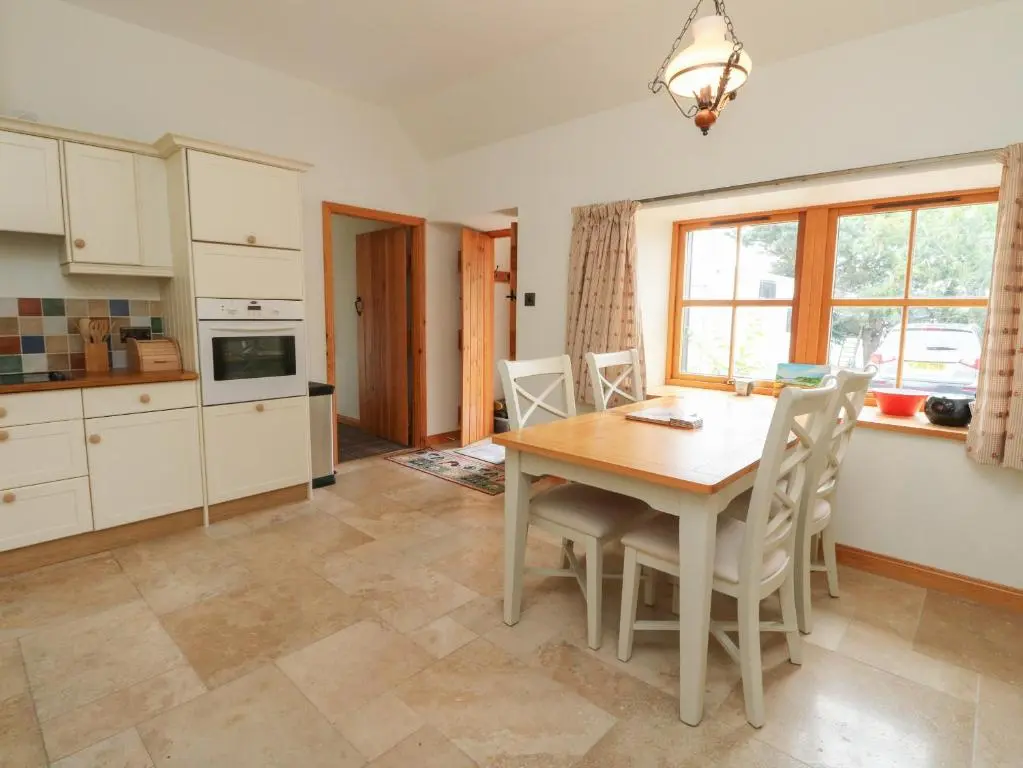 a kitchen and dining room with a table and chairs at The Milk House in Fortrose