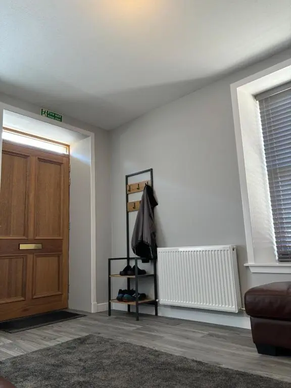 a room with a door and a shelf with shoes at Argyle House Wick in Wick