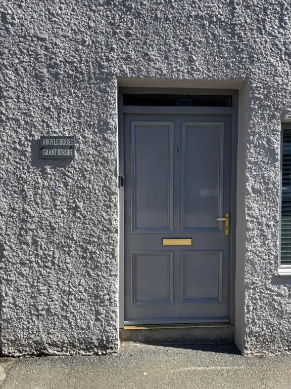 a blue door of a building with a sign on it at Argyle House Wick in Wick
