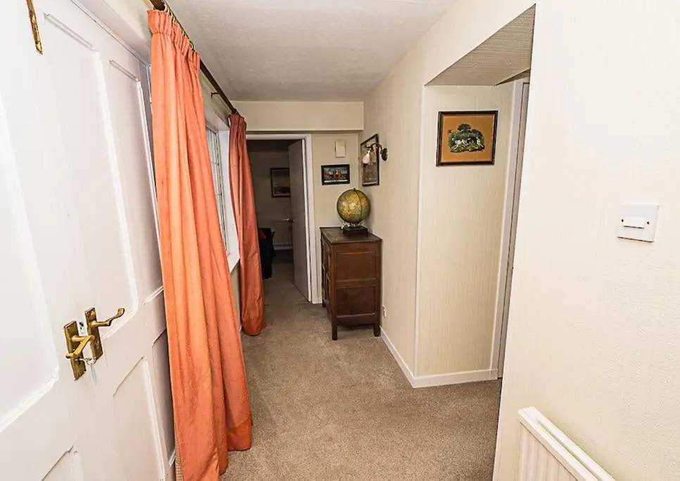 a hallway with an orange curtain and a door at West Lodge 3 bedrooms, near golf course and river in Turriff