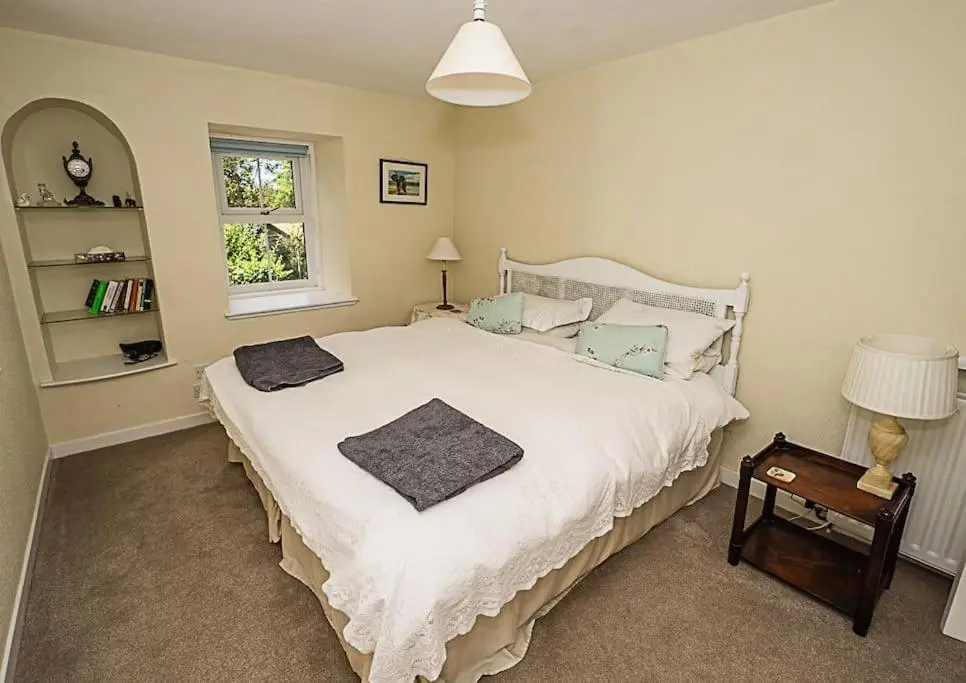 a bedroom with a white bed and a window at West Lodge 3 bedrooms, near golf course and river in Turriff