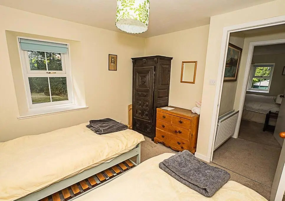 a bedroom with two beds and a dresser and a window at West Lodge 3 bedrooms, near golf course and river in Turriff