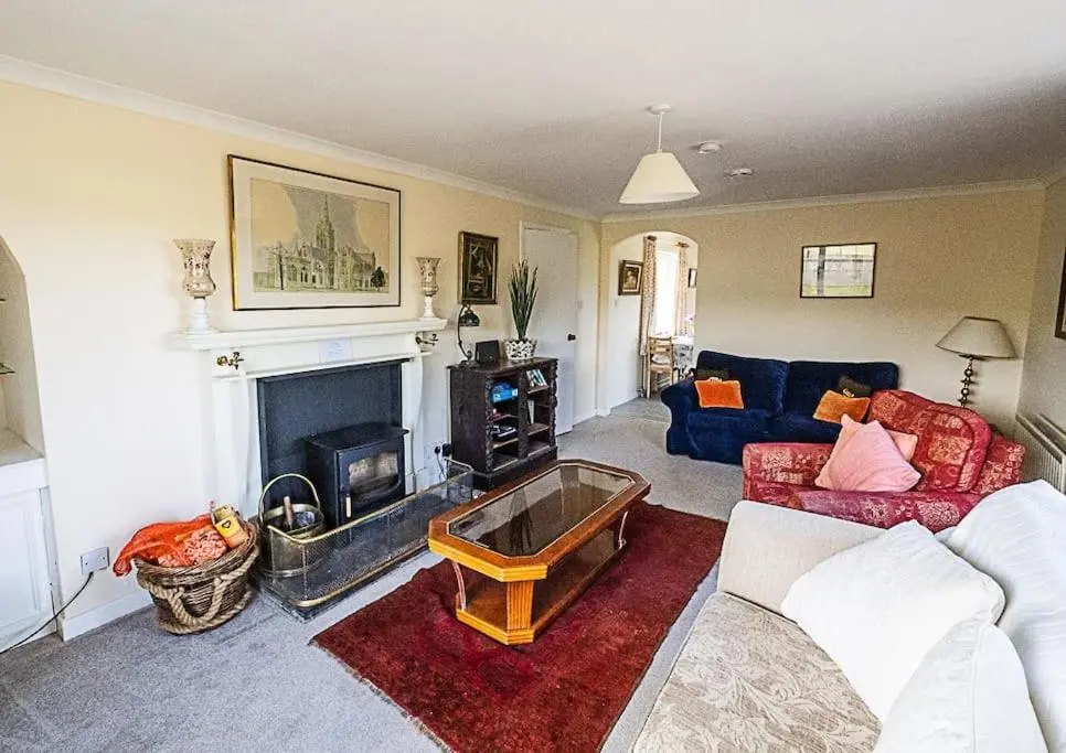 a living room with a couch and a fireplace at West Lodge 3 bedrooms, near golf course and river in Turriff