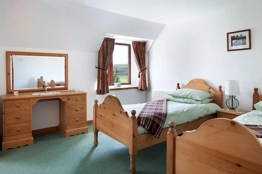 a bedroom with a bed and a desk and a mirror at Mackenzie in Belmaduthy
