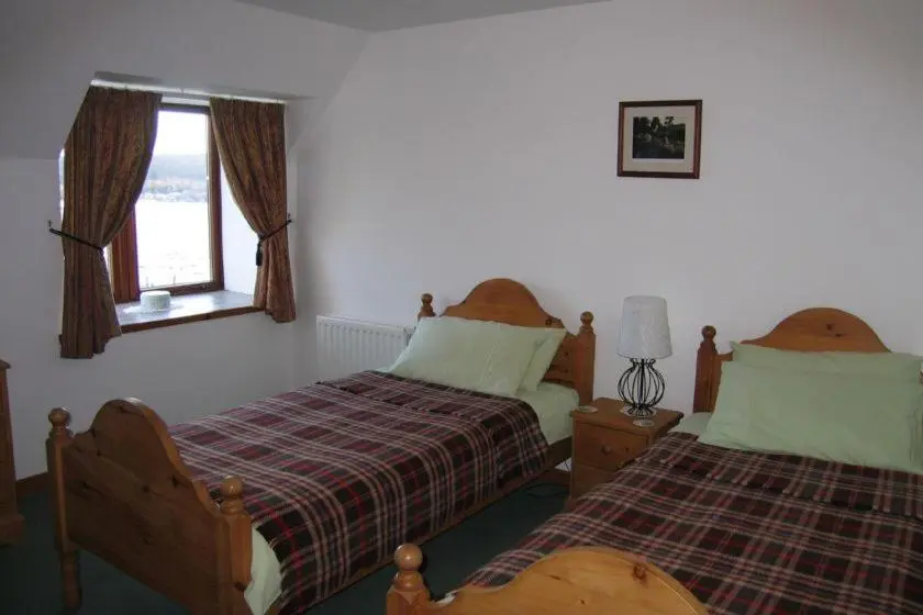 a bedroom with two beds and a window at Mackenzie in Belmaduthy