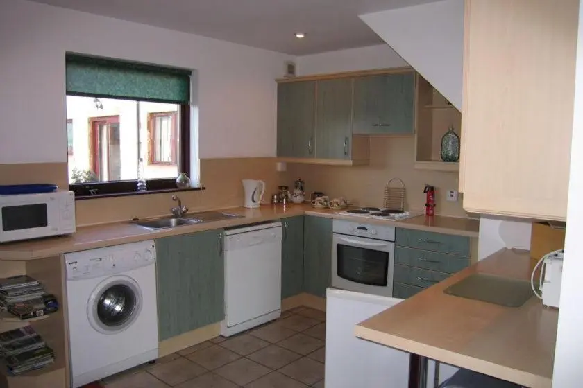 a kitchen with a sink and a washing machine at Mackenzie in Belmaduthy