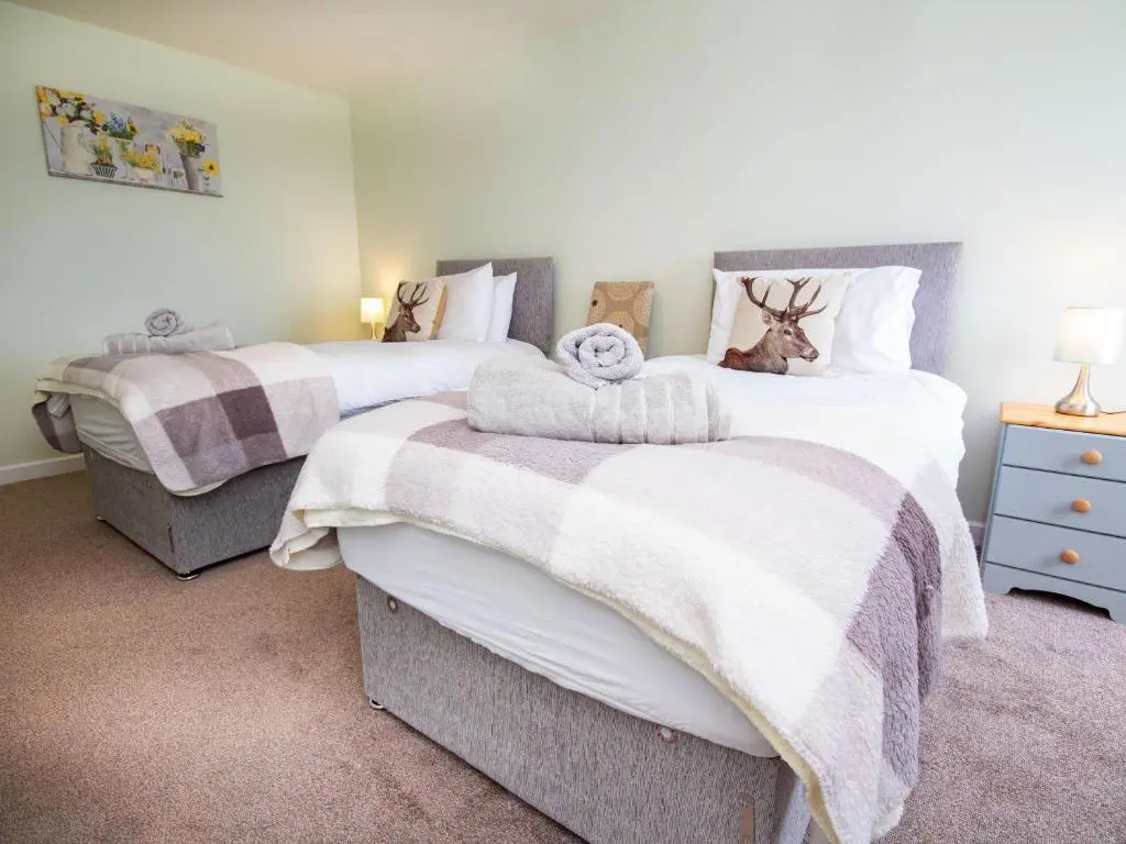 a bedroom with two beds with towels on them at Cranberry Cottage in Wick