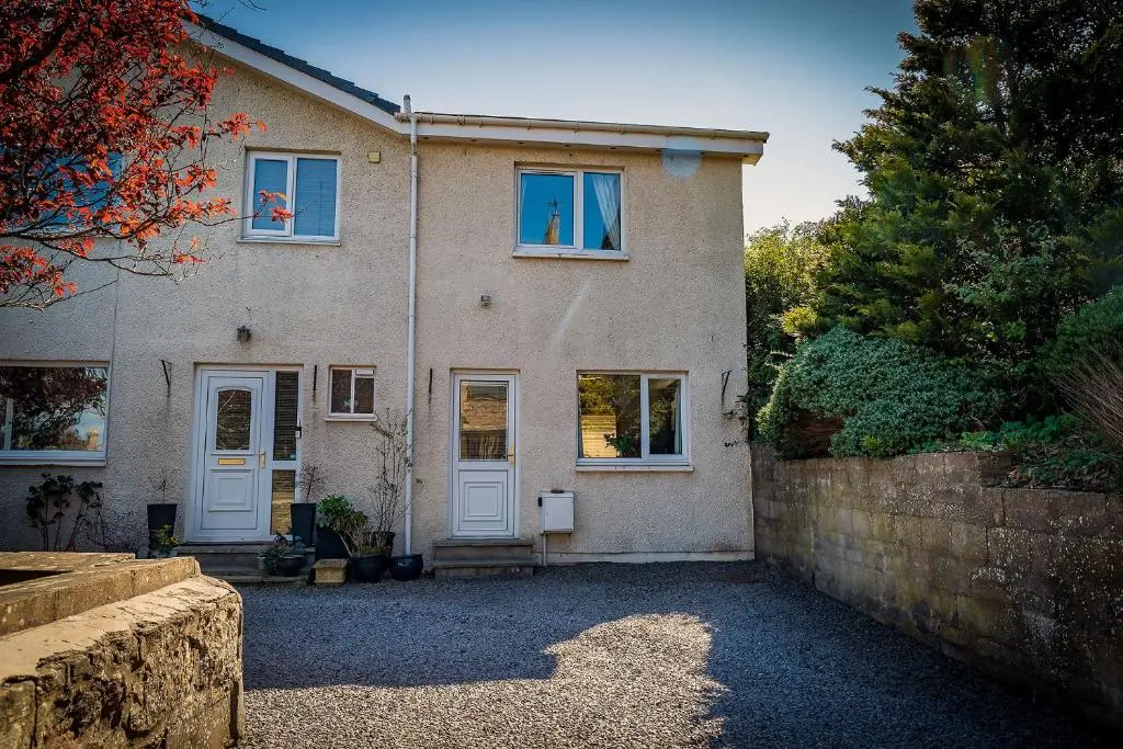 a house with white doors and a stone wall at Fonthill Bed and Breakfast Nairn in Nairn