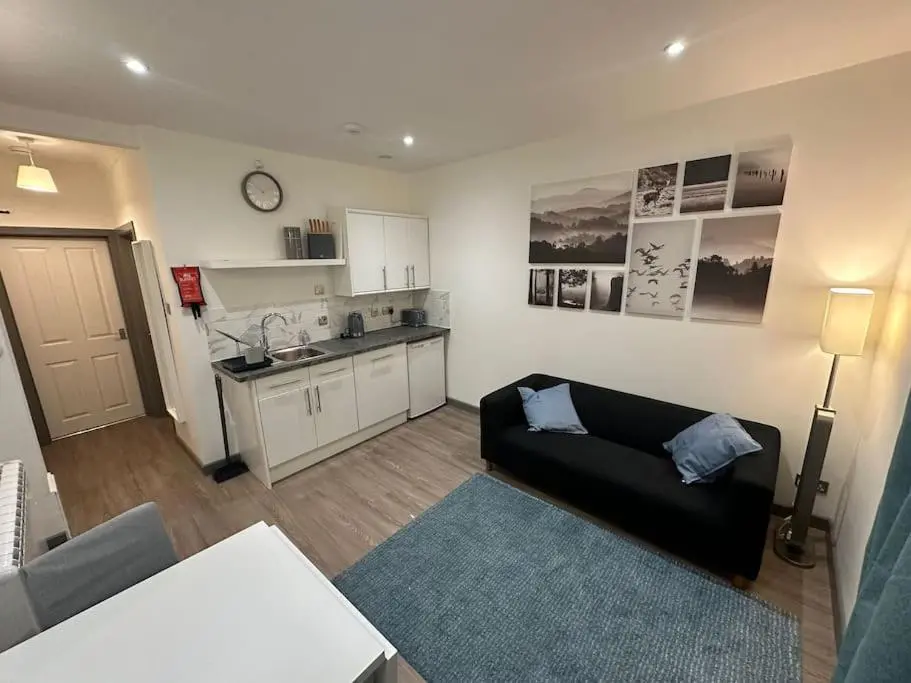 a living room with a couch and a kitchen at Riverview Apartment, Inverness in Inverness