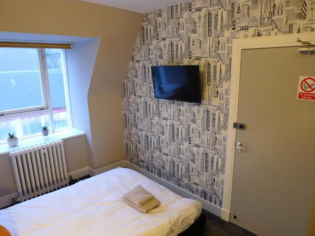 a bedroom with a wall covered in drawings of buildings at Saltoun House in Fraserburgh