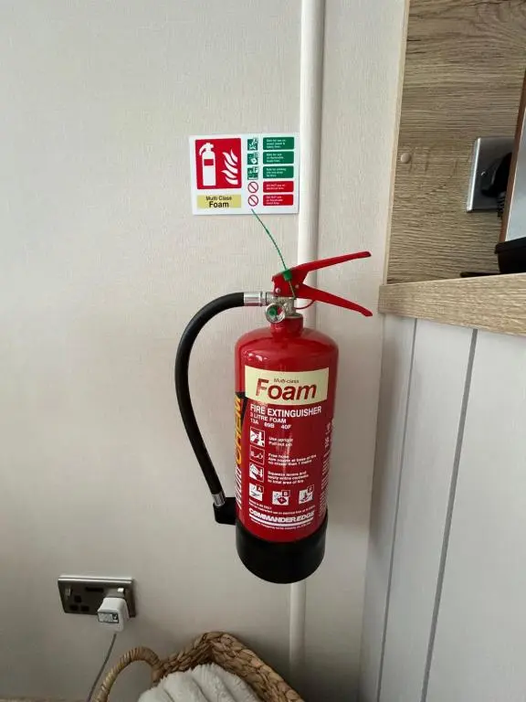 a fire extinguisher hanging on the wall of a room at Lodge 2 The Wee Hut Aviemore in Aviemore