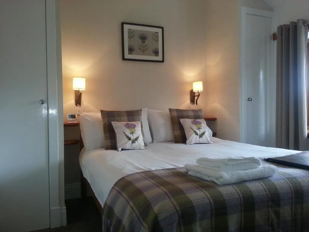 a bedroom with a bed with two pillows on it at Ardlogie Guest House in Aviemore