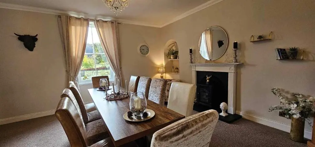 a dining room with a table and chairs and a mirror at Antfield House in Inverness