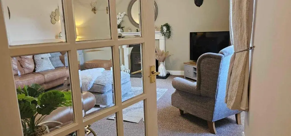 a living room with a couch and a chair and a television at Antfield House in Inverness