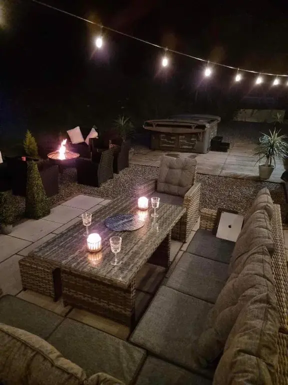 a patio at night with a table and a couch at Antfield House in Inverness