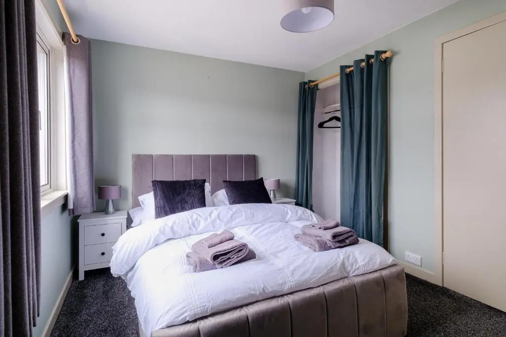 a bedroom with a bed with two towels on it at Banchory House - SJA Stays - 2 Bed House in Banchory