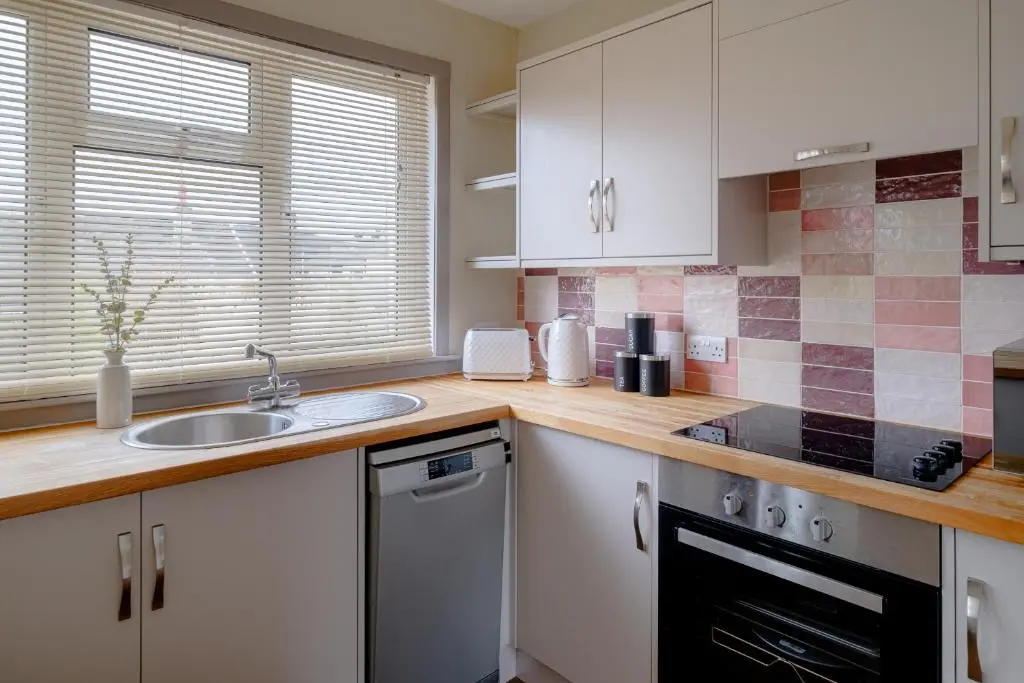 a kitchen with white cabinets and a sink at Banchory House - SJA Stays - 2 Bed House in Banchory