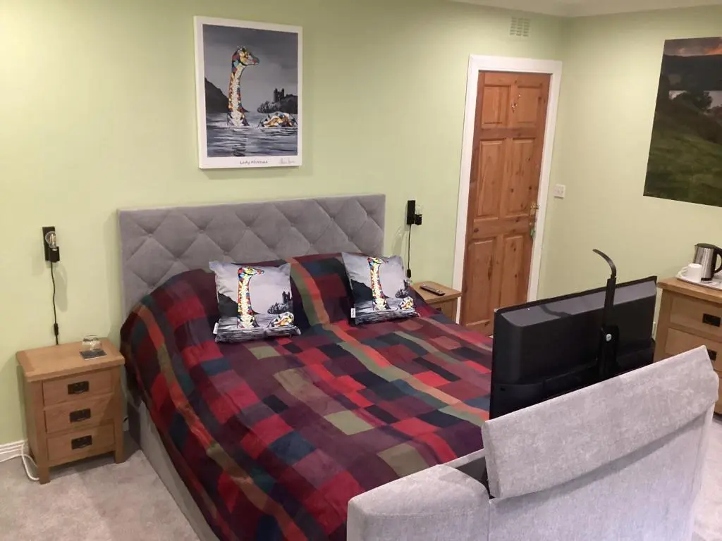 a bedroom with a bed and a couch at Taigh Sealladh F\u00e8idh B&B in Fort Augustus