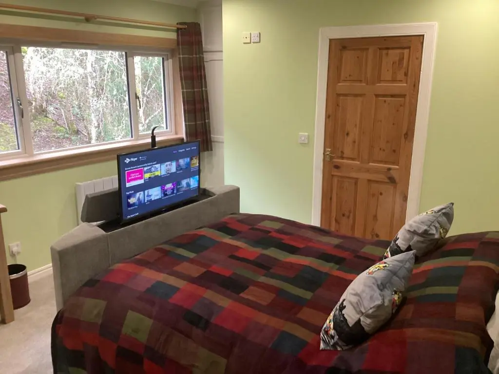 a bedroom with a bed with a flat screen tv at Taigh Sealladh F\u00e8idh B&B in Fort Augustus