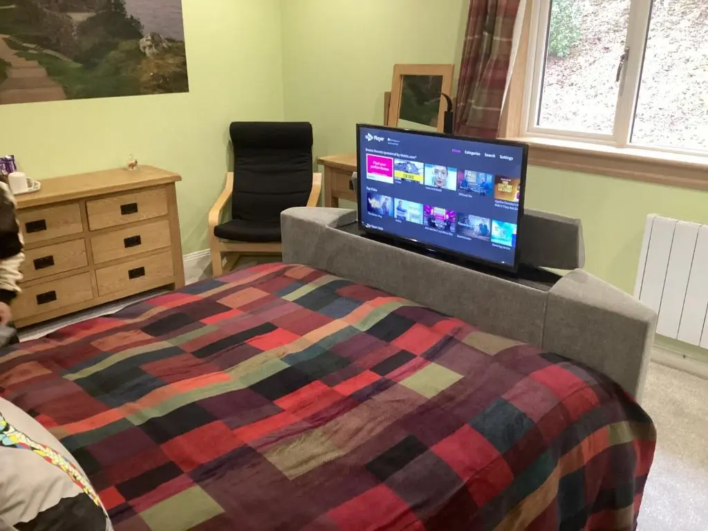 a bedroom with a bed and a flat screen tv at Taigh Sealladh F\u00e8idh B&B in Fort Augustus