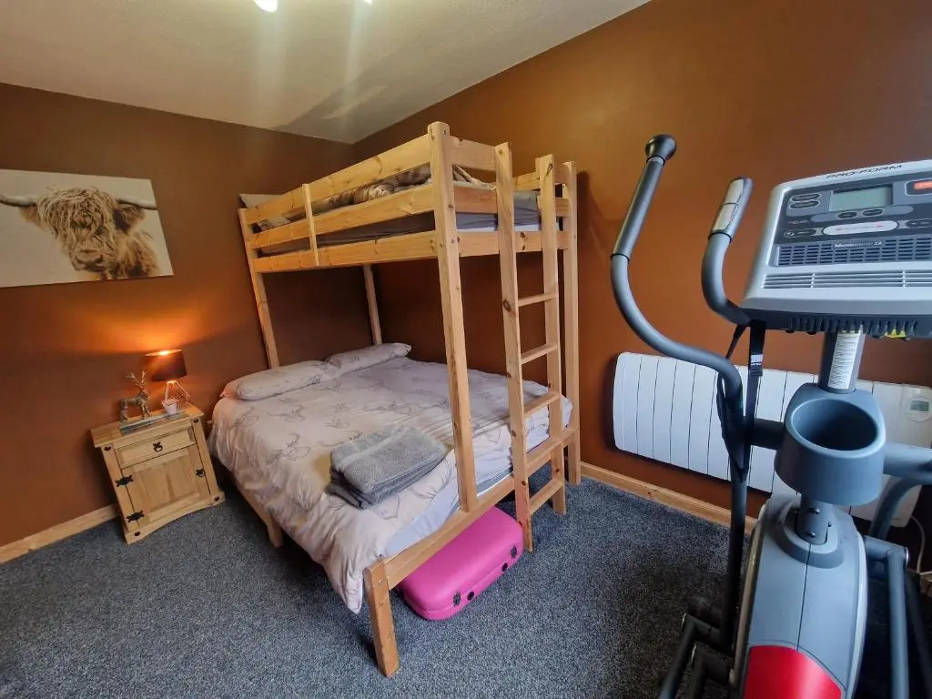 a bedroom with a bunk bed and a treadmill at Town centre house, Hot tub, Cinema room and Gym in Aviemore