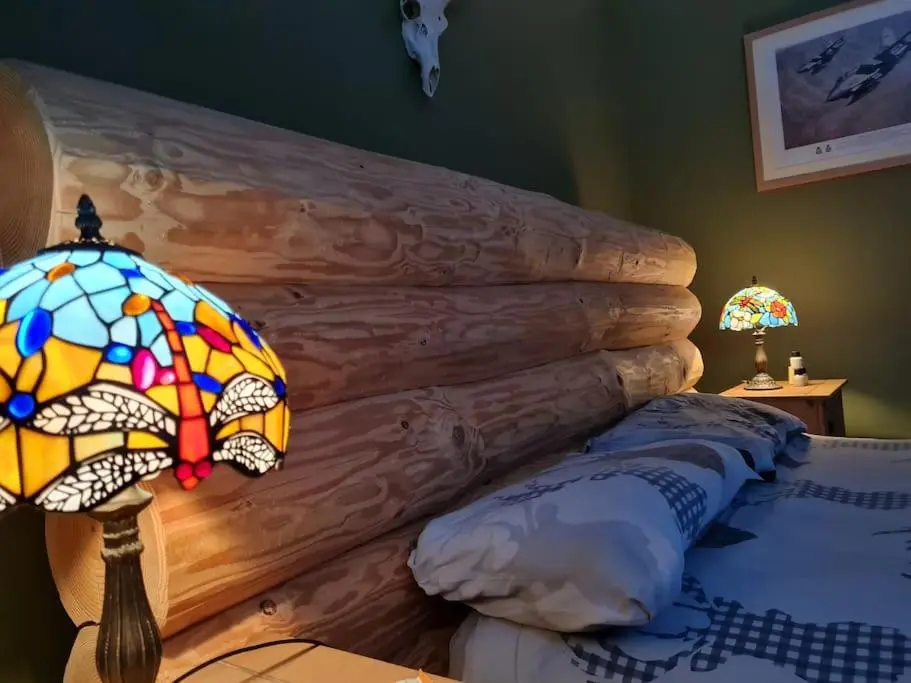 a bedroom with a bed with a stained glass umbrella lamp at Town centre house, Hot tub, Cinema room and Gym in Aviemore