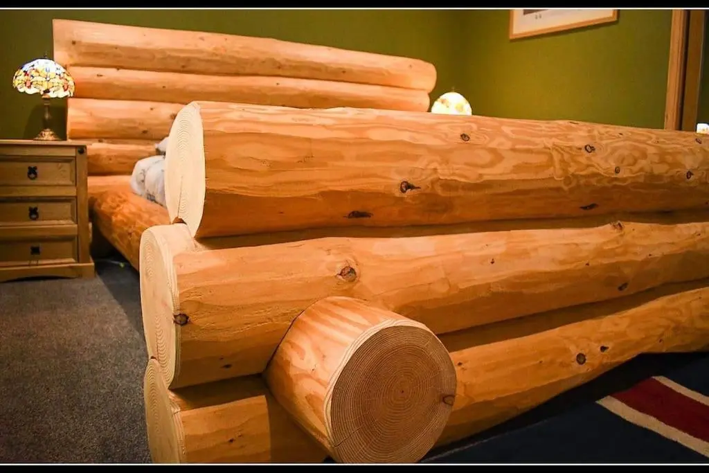 a bed made out of logs in a room at Town centre house, Hot tub, Cinema room and Gym in Aviemore