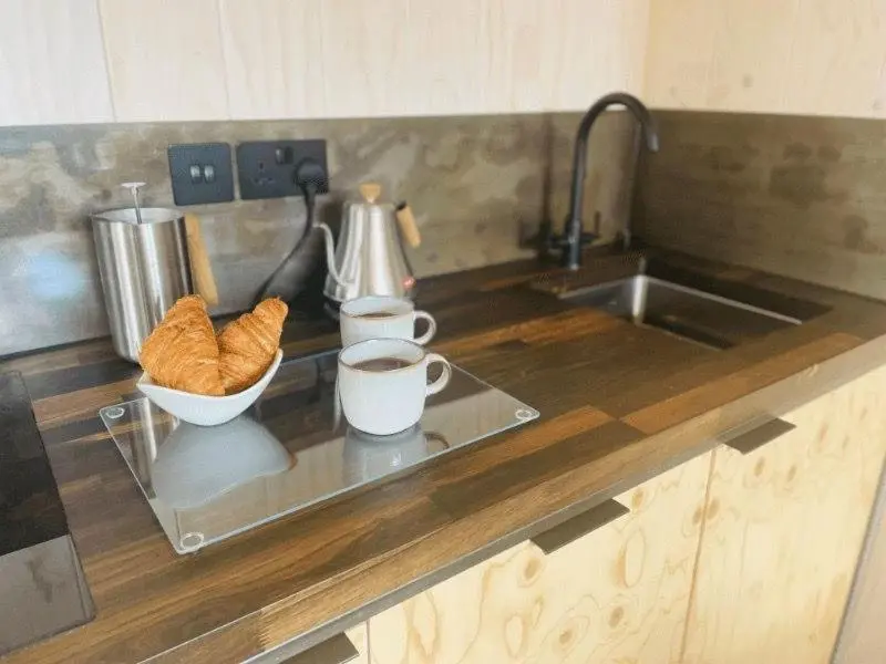 a kitchen counter with a sink and a bowl of bread at Dog friendly cabin & hot tub and Cairngorm views in Aviemore