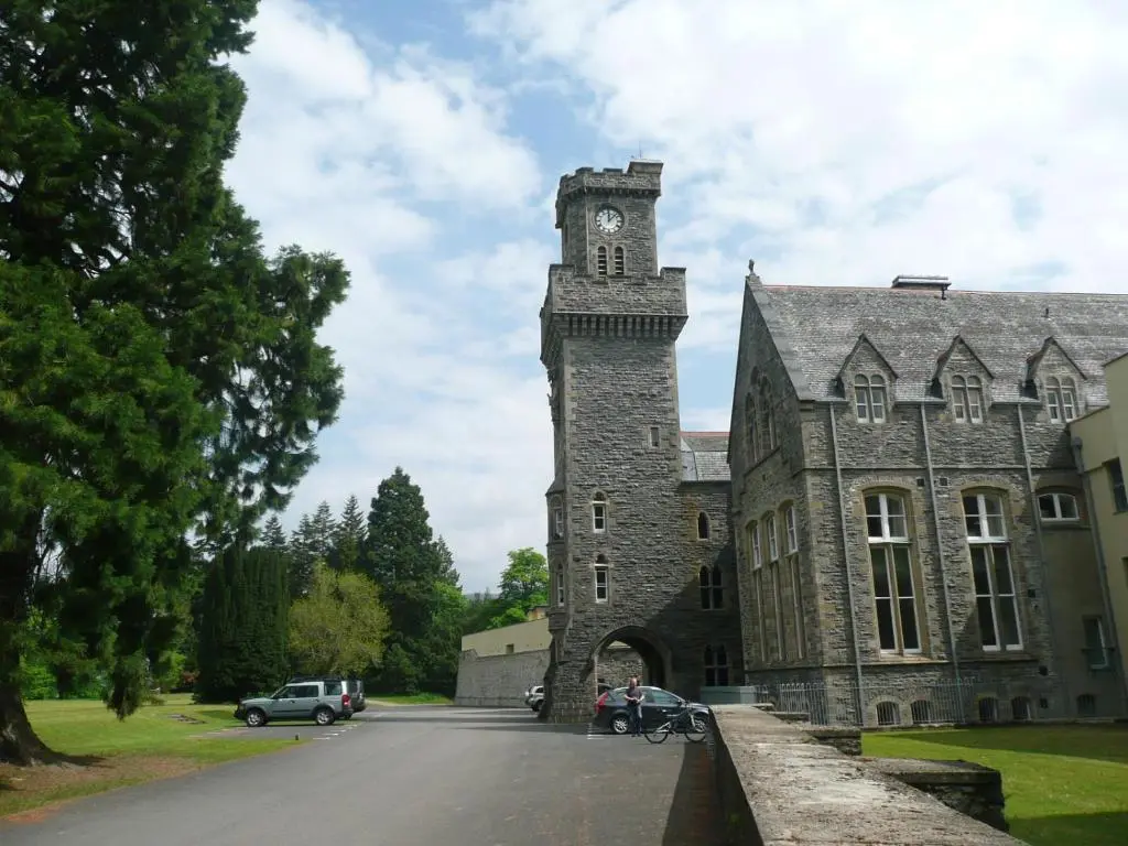 a large stone building with a clock tower at Noble Apartment - Highland Club in Fort Augustus
